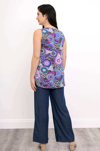 Full body back view of woman wearing sleeveless purple mandala patterned top and tencel denim pants