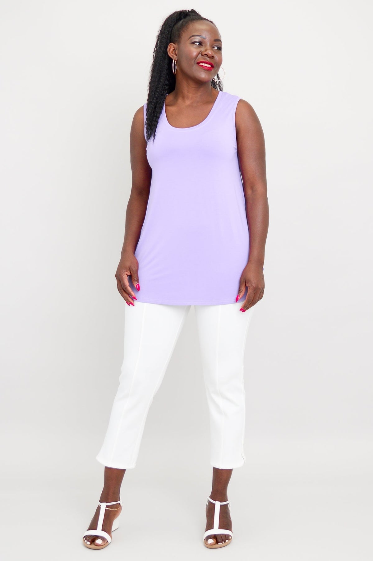 woman modelling a loose-fit light purple sleeveless bamboo top and slim fit white pants