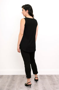 Woman wearing a black sleeveless top and black pants against a white background, back view