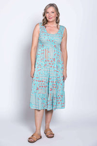 Woman in blue sleeveless dress with red flowers, angled front view