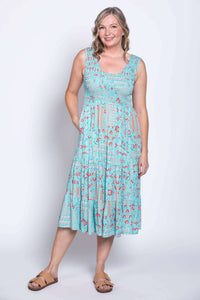 Woman in a blue and red floral sleeveless dress, front view with pockets