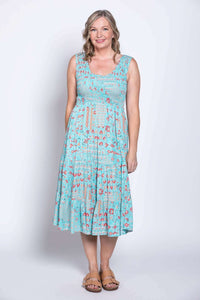Woman in light blue, red floral sleeveless dress, standing front-facing