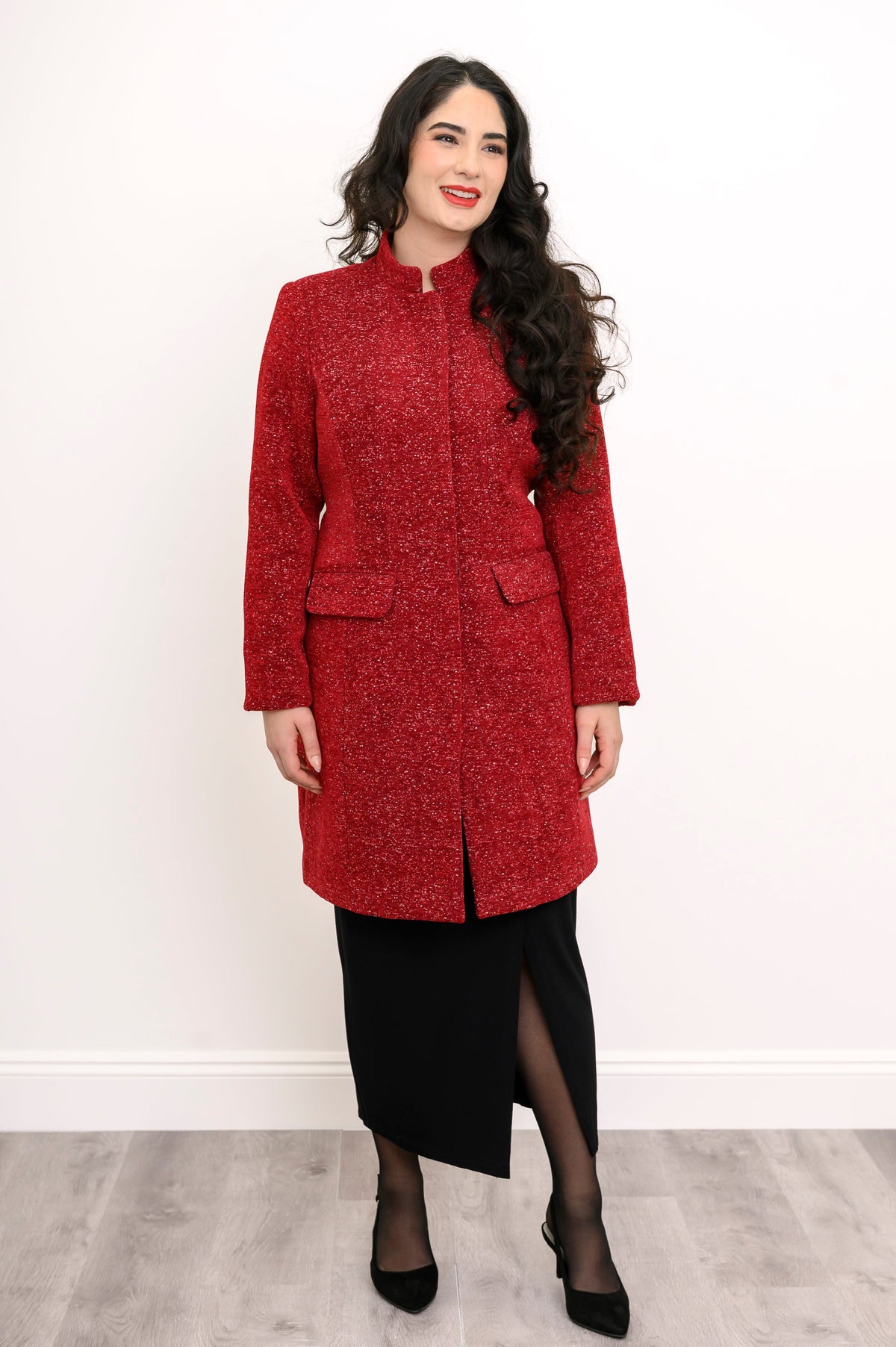 Slightly angled view of woman in textured wool coat and black skirt with slit detail