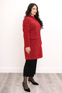 Side view of woman wearing long red coat with mandarin collar and flap pockets
