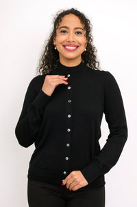 Woman modeling a monochromatic black outfit featuring a long sleeve crewneck cardigan and trousers.