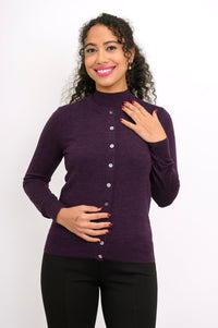 Front view of woman wearing a purple cardigan on a purple top and black pants against a white background