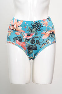 Tropical floral pattern brief underwear on a white mannequin torso, featuring a turquoise base with pink hibiscus.
