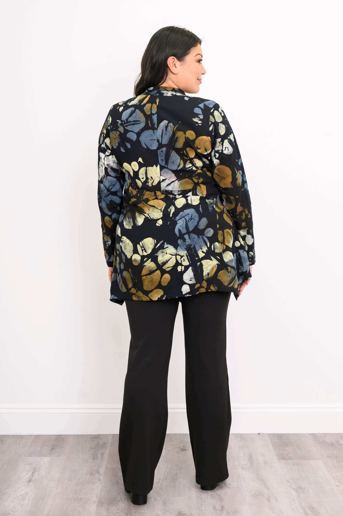 Back view of woman wearing Laney Blouse Night Bloom with black pants