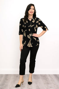 Woman wearing a black blouse with tan leaf pattern and black pants against a white background, front view