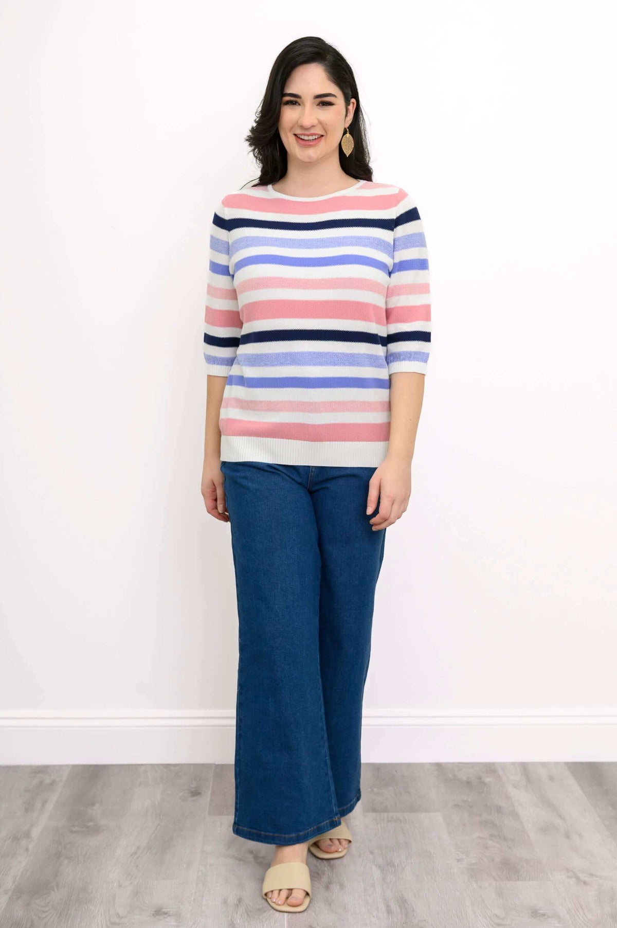 Front view of Sweater with multi-colored stripes and blue denim pants
