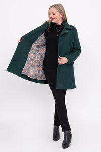 full body shot of woman wearing a green coat with a floral lining on a white background