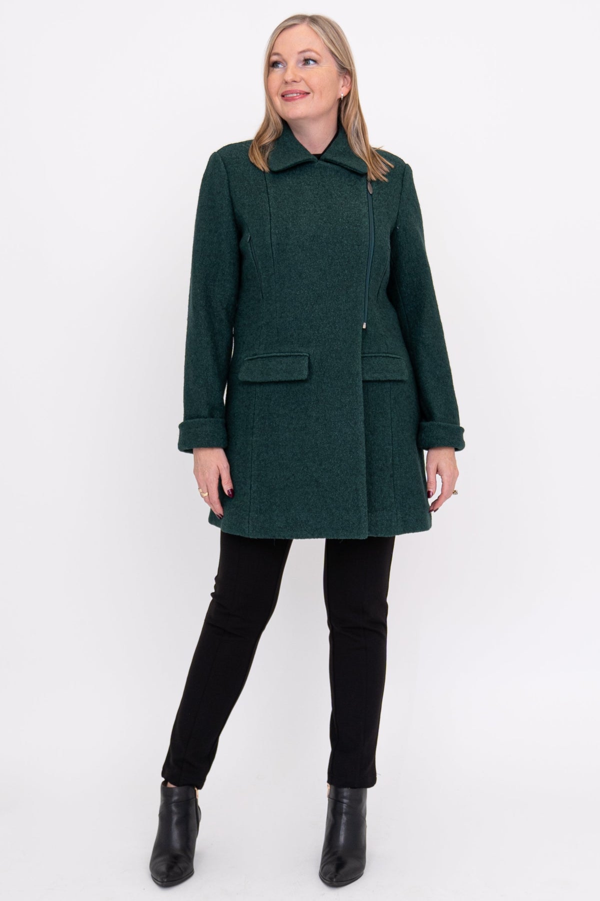 Woman wearing a green coat, black pants, and black shoes on a white background, front view