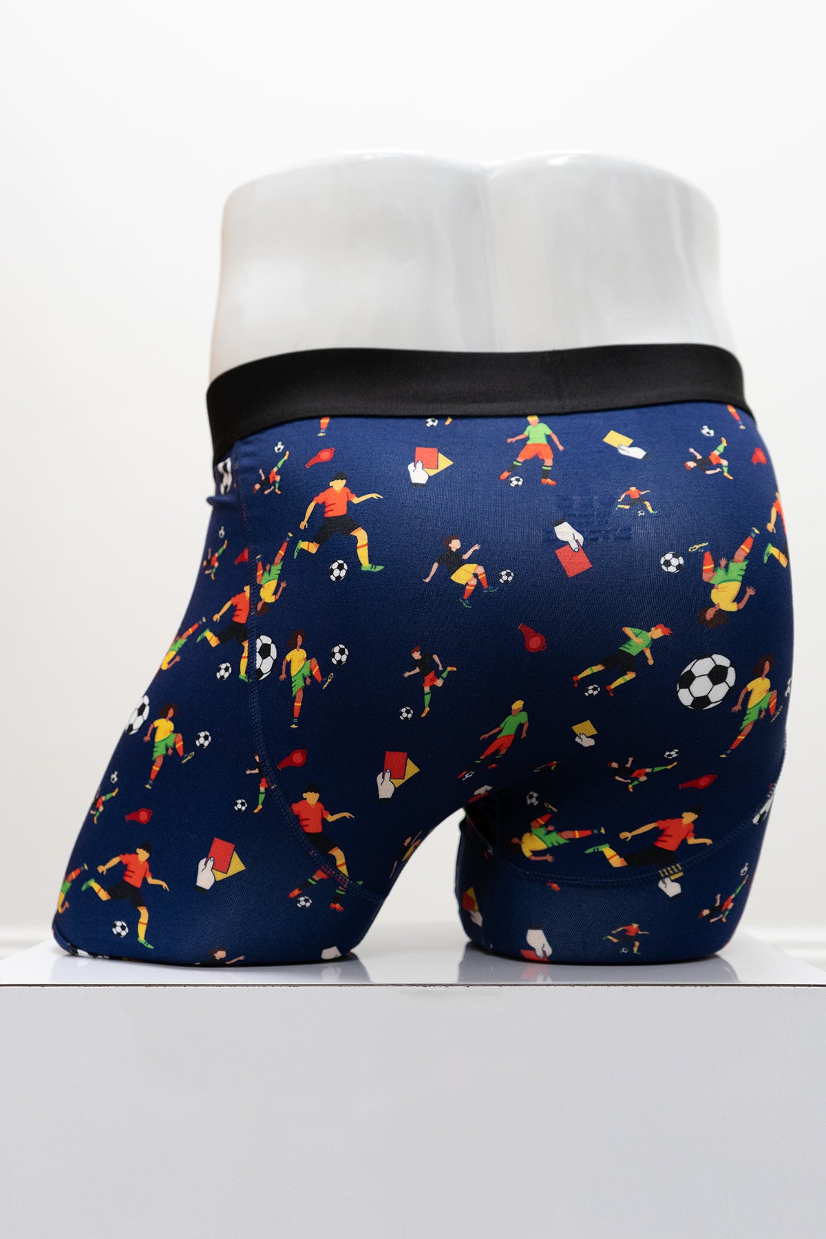 Navy boxer briefs with soccer-themed print and 'Blue Sky Guy' waistband on a white mannequin, back view