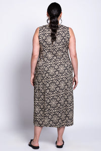 Back view of model wearing sleeveless long dress with black and beige floral geometric pattern