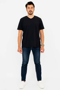 Man in black high V-neck t-shirt and jeans, standing straight, full body front view