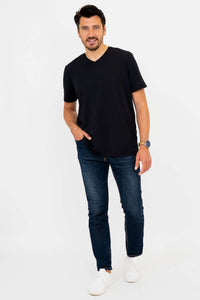 Man in black high V-neck t-shirt and jeans, walking pose, full body front view