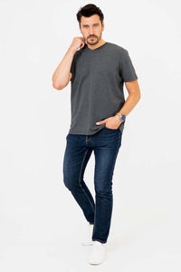 Man posing with hand to face in dark grey V-neck T-shirt