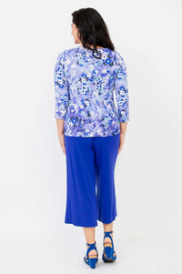 Back view of a woman in a blue floral 3/4 sleeve tee and royal blue wide-leg pants