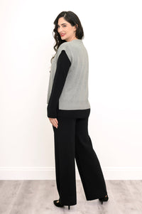 Side-facing view of a women's gray button-down vest styled with black pants against a plain white backdrop.
