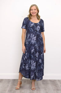 Front view of woman wearing long navy blue floral dress and sandals on a white background