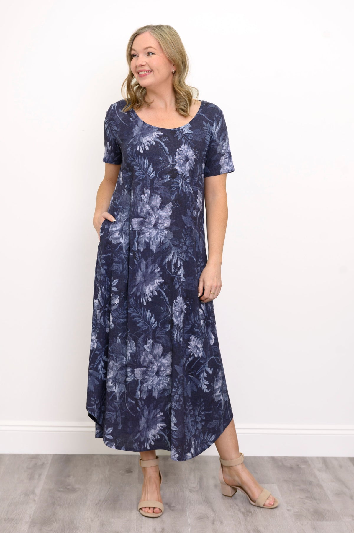 Front view of woman modelling a short sleeve maxi dress with rounded hem, posing with her hand in her pocket