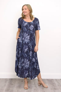 Front view of woman modelling a short sleeve maxi dress with rounded hem, posing with her hand in her pocket