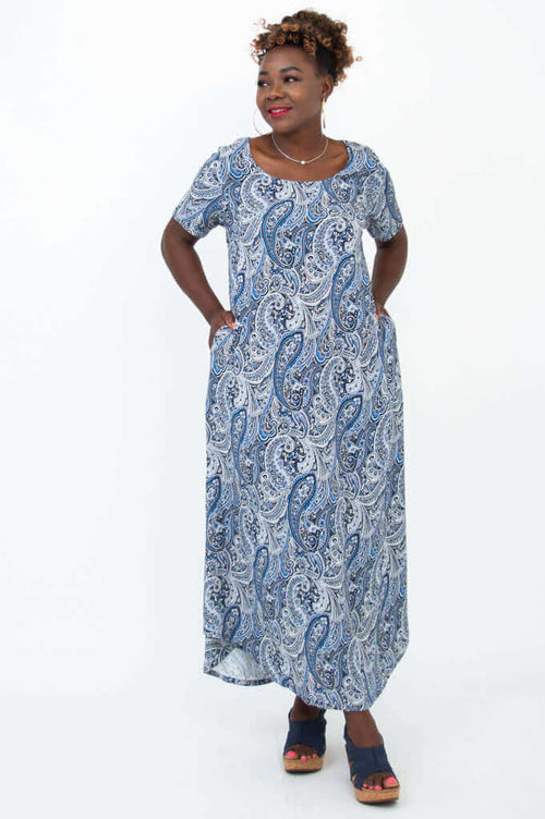 Side front angle of woman in blue paisley Martha maxi dress, hands in pockets