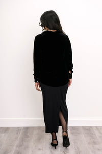 Back view of a luxury women's black silk velvet shirt styled with a black maxi dress look