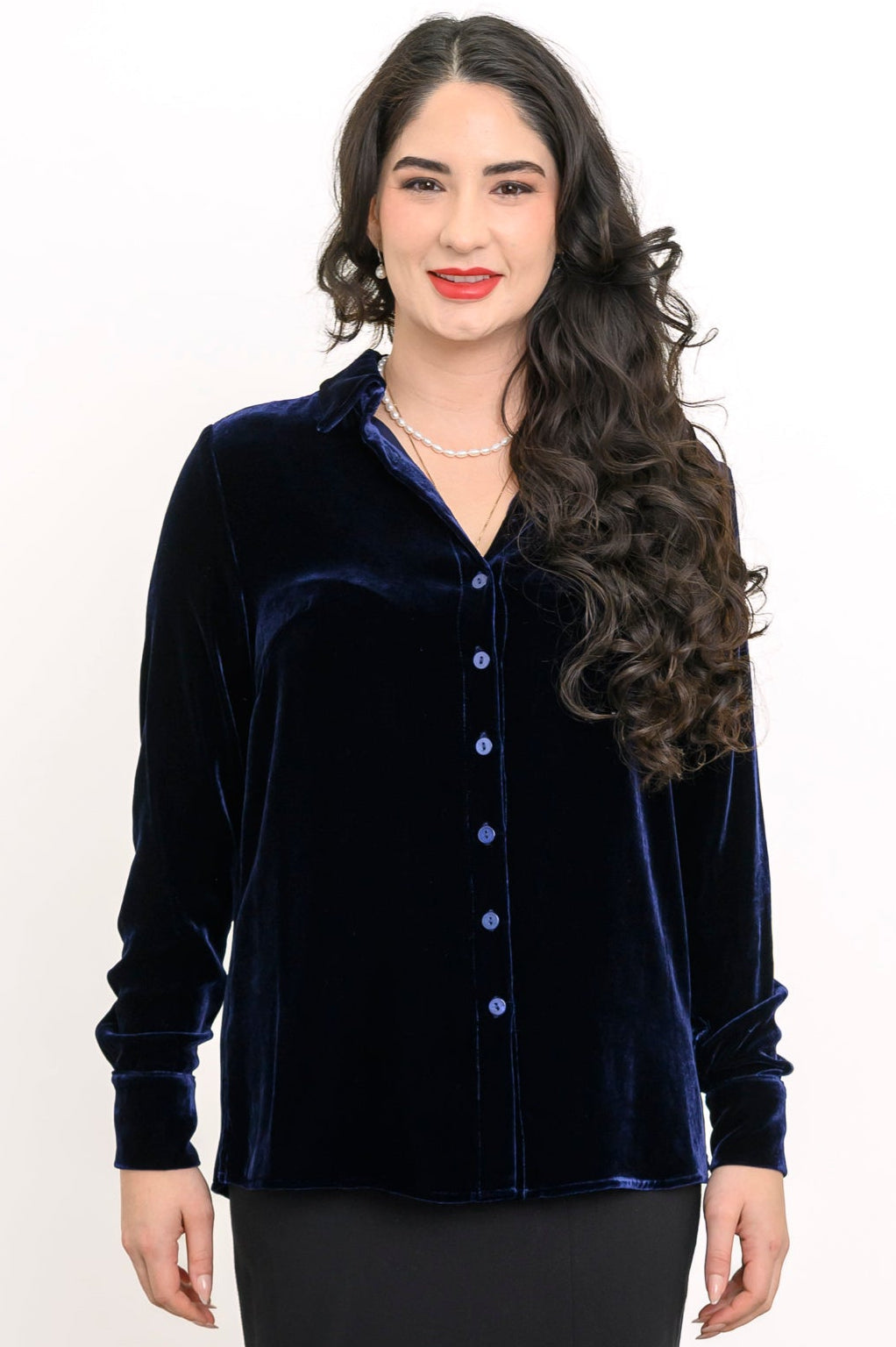 Front view of a smiling woman wearing a navy blue silk velvet button-up shirt with a classic collar