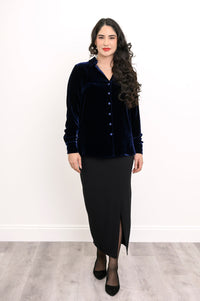 Wide studio shot of an elegant women's dark blue velvet long-sleeve blouse paired with a long black skirt and heels
