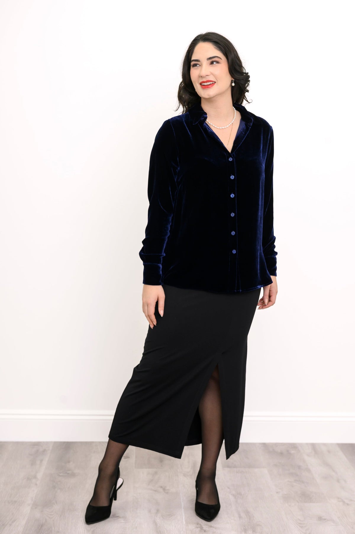 Straight-on full body portrait of a navy blue silk velvet button-down shirt styled with a black maxi skirt