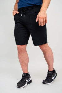 Side view of men's black shorts with relaxed hand position