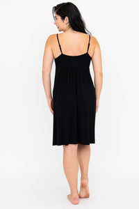 Back view of a woman wearing the black Mina Slip Dress.