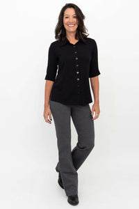 Woman wearing granite grey flare pants with a black button-up shirt