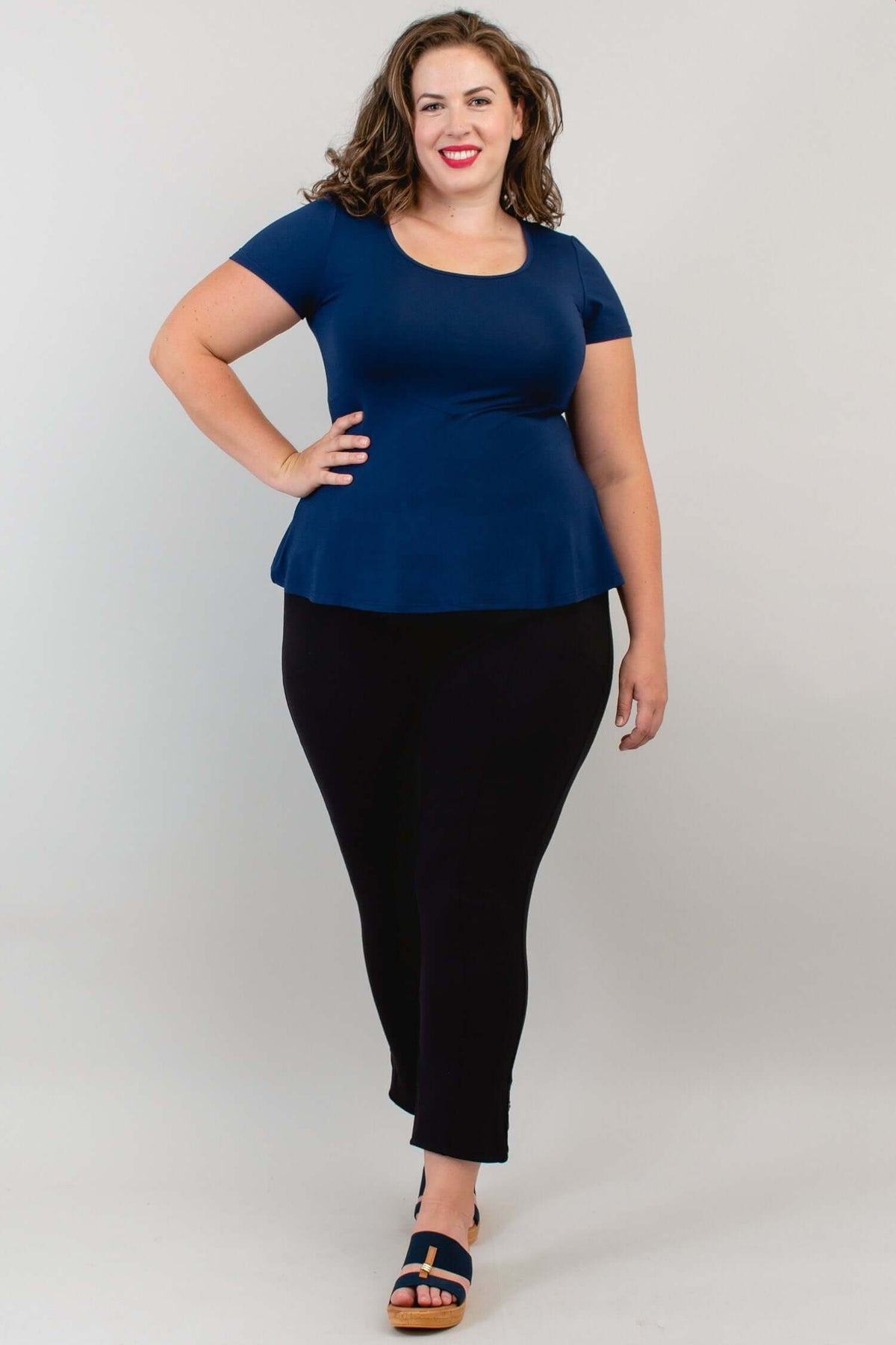 Model in navy Kim Cap Top and black pants, hand on hip, full view
