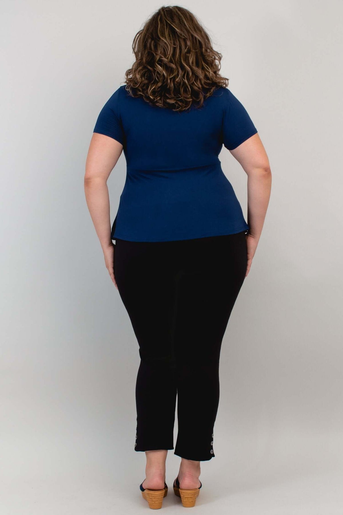 Model showing back view of Kim Cap Top in navy with black pants