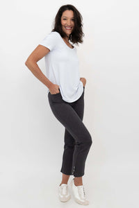 Woman in Nadine Crop Pants and white shirt, side pose with hands in pockets