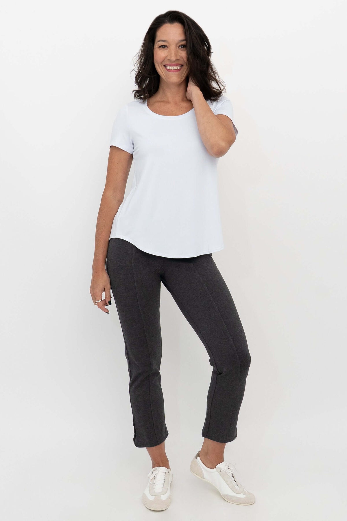 Woman wearing Nadine Crop Pants in charcoal grey with a white top, front view