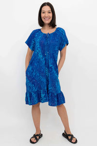 Woman with hands in pockets modeling blue patterned Samoa Dress with relaxed fit