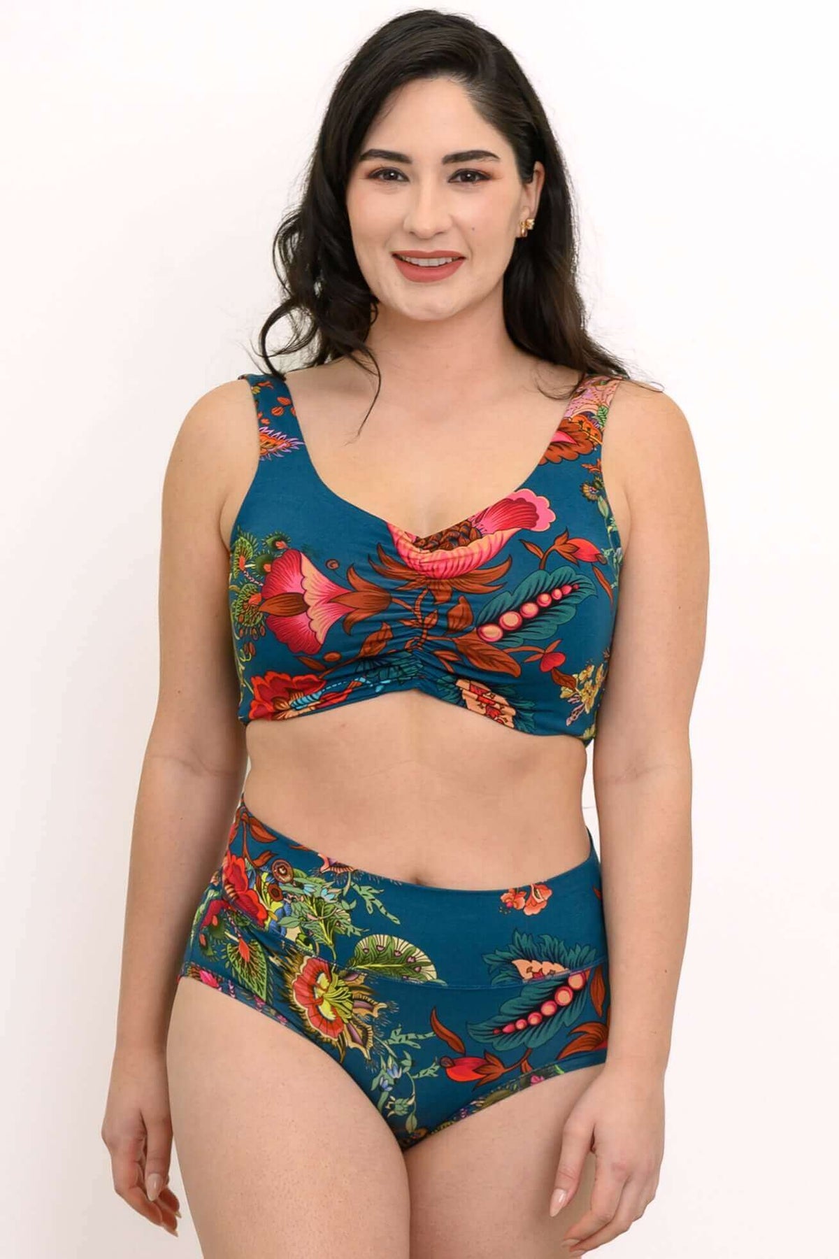 Model wearing a teal crop top and high-waisted bottoms with vibrant floral print