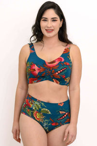 Model wearing a teal crop top and high-waisted bottoms with vibrant floral print