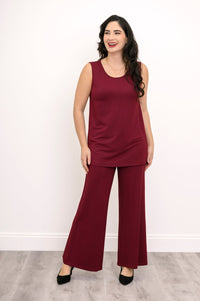 Wide studio shot of a relaxed-fit burgundy bamboo French terry sleeveless top styled with monochrome trousers.