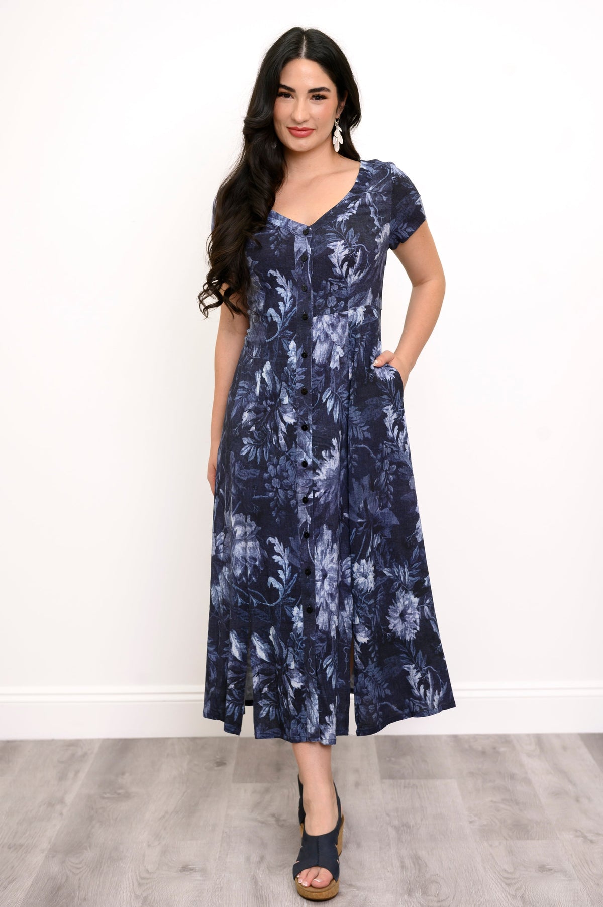 Woman wearing a navy blue floral print maxi dress, putting her hand in her pocket