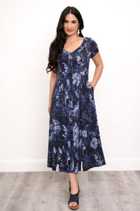 Woman wearing a navy blue floral print maxi dress, putting her hand in her pocket