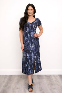 Full body view of woman with her hand on her hip modeling a short sleeve dark floral dress with buttons