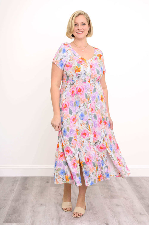 Model wearing a colourful floral button-front dress with cap sleeves and slits