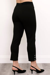 Back view of woman wearing high-waisted black slim fit pants and black heels