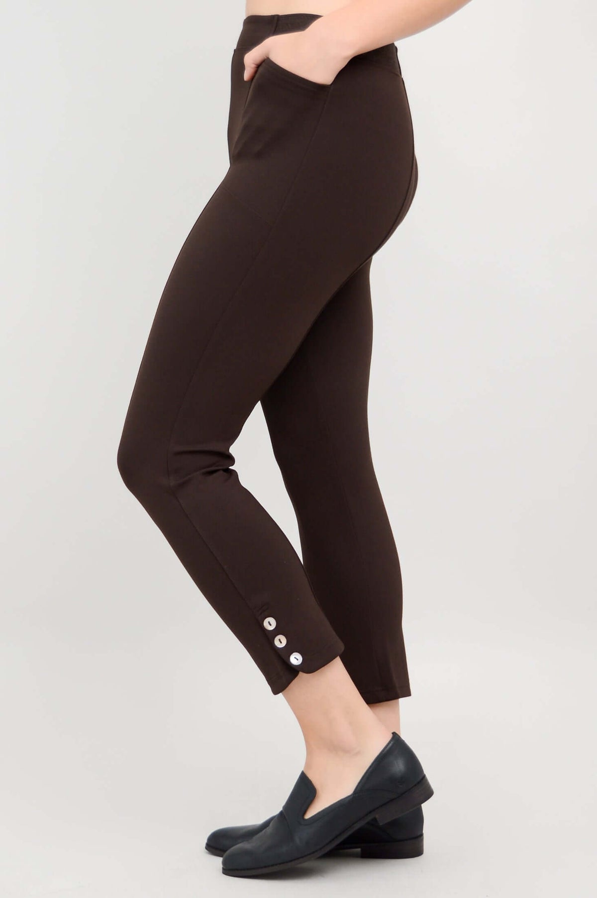 Side view of Nadine Crop Pants in chocolate, highlighting button detail at the ankle and pocket