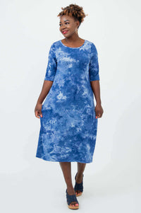 Woman in blue tie dye Olivia dress smiling, showing front style