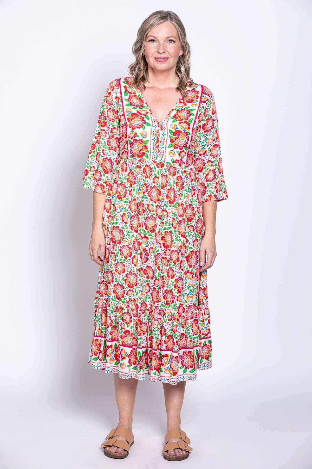 Woman in Oma floral batik dress looking forward, arms at sides